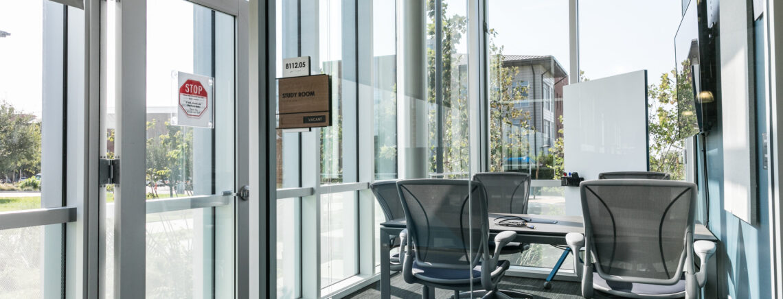 image about a study room at ACC. There are chairs and a table, and instead of walls, there is glass.