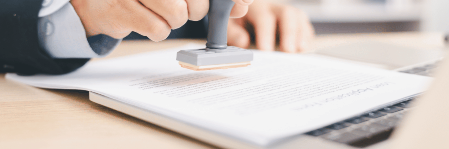 Hand stamping a document with a "Course Approval" seal
